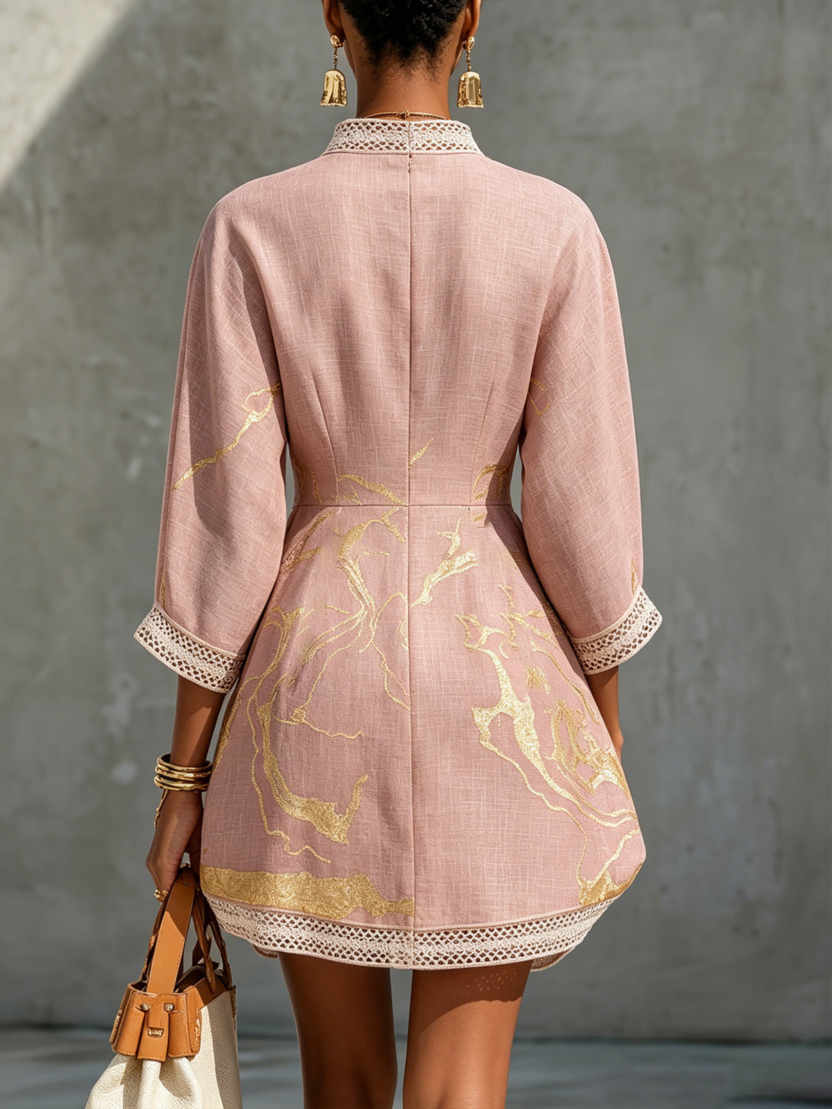 Aurelia crochet lace mini dress in pink, back view with gold motifs and lace-trimmed sleeves.