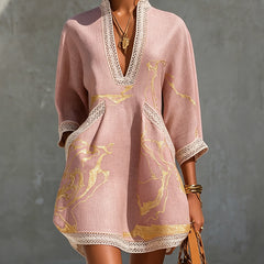 Aurelia crochet lace mini dress in pink with gold pattern, deep V-neck and lace trim.