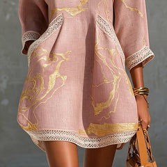Aurelia crochet lace mini dress in pink with gold swirling print and lace hem border.