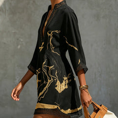Black mini dress, side view: deep V neckline, crochet lace cuffs and gold abstract print