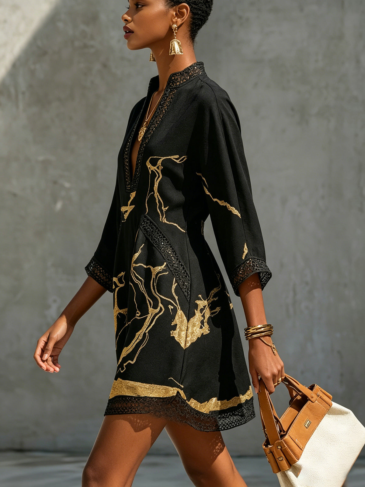 Black mini dress, side view: deep V neckline, crochet lace cuffs and gold abstract print