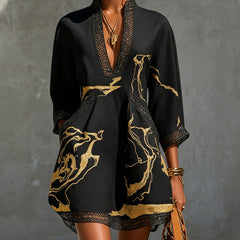 Black mini dress with V-neck crochet lace trim and gold abstract print, long sleeves
