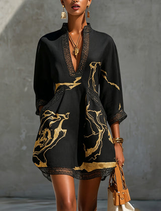 Black mini dress with V-neck crochet lace trim and gold abstract print, long sleeves