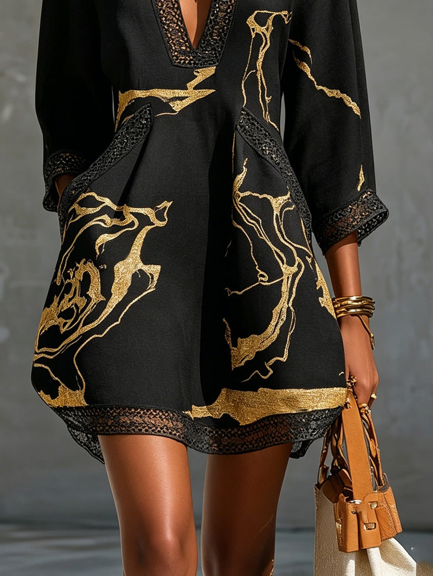 Black mini dress close-up: gold abstract print with crochet lace trim at hemline