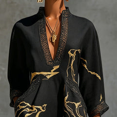 Black mini dress close-up: V-neck crochet lace trim with gold abstract motif print