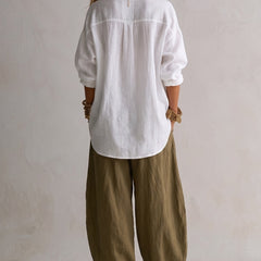 Two-piece linen set: back view white button-up blouse with gold buttons, olive relaxed pants