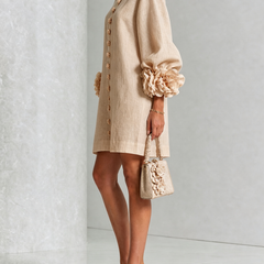 Tan button-down mini dress with long sleeves and large rosette cuff accents