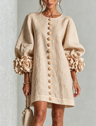 Beige button-down mini dress with long sleeves, embroidered button front, and rosette cuffs