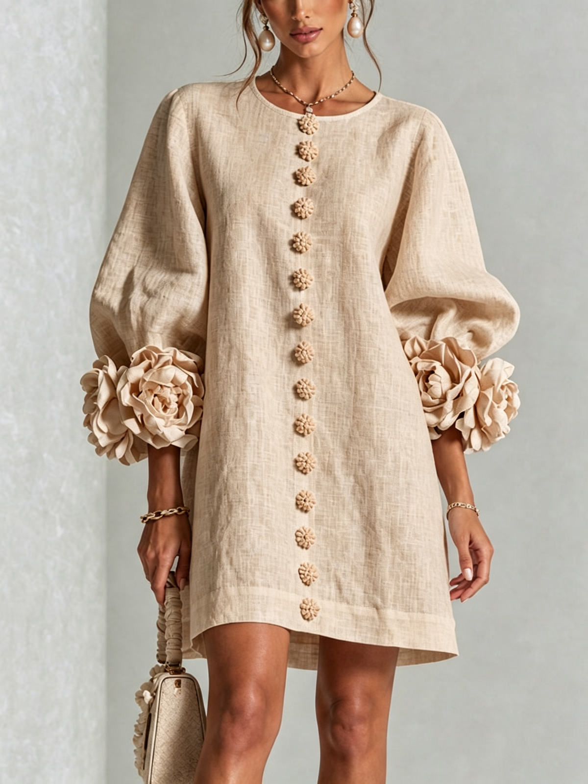 Beige button-down mini dress with long sleeves, embroidered button front, and rosette cuffs