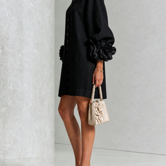 Black button-down mini dress with rosette puff sleeves and front button detail