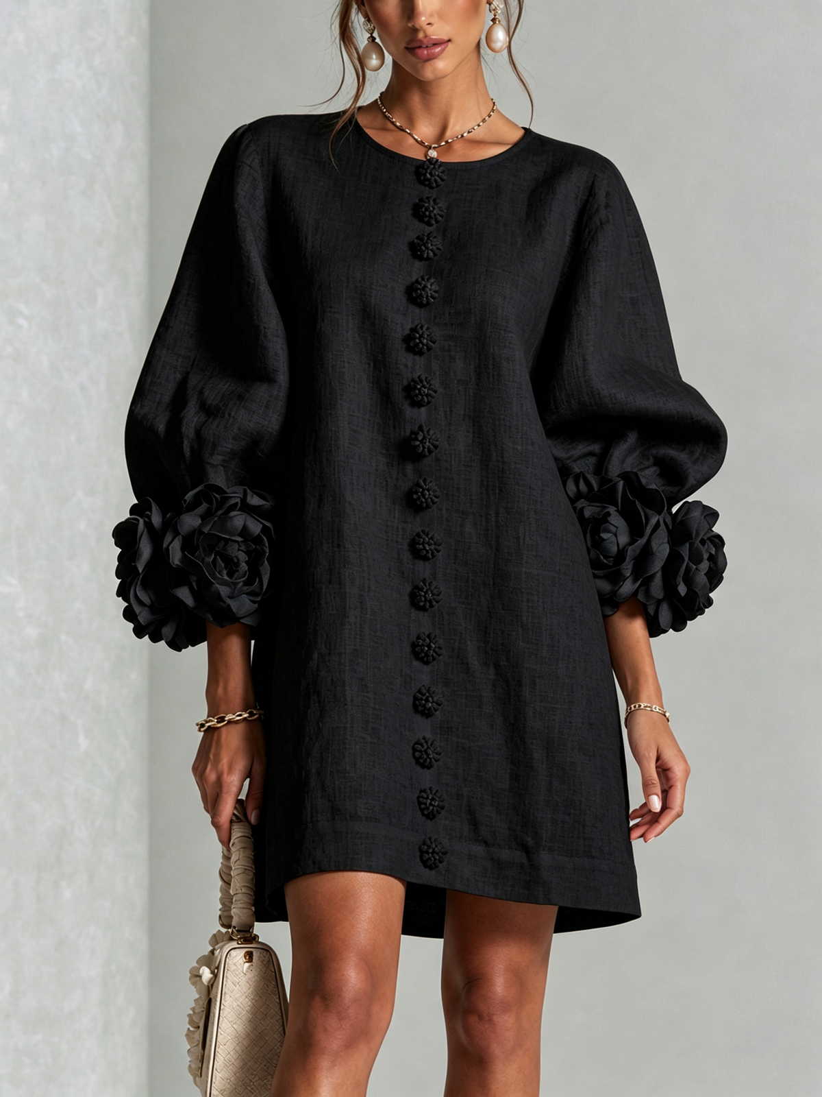 Black button-down mini dress with vertical button placket and large rosette sleeves