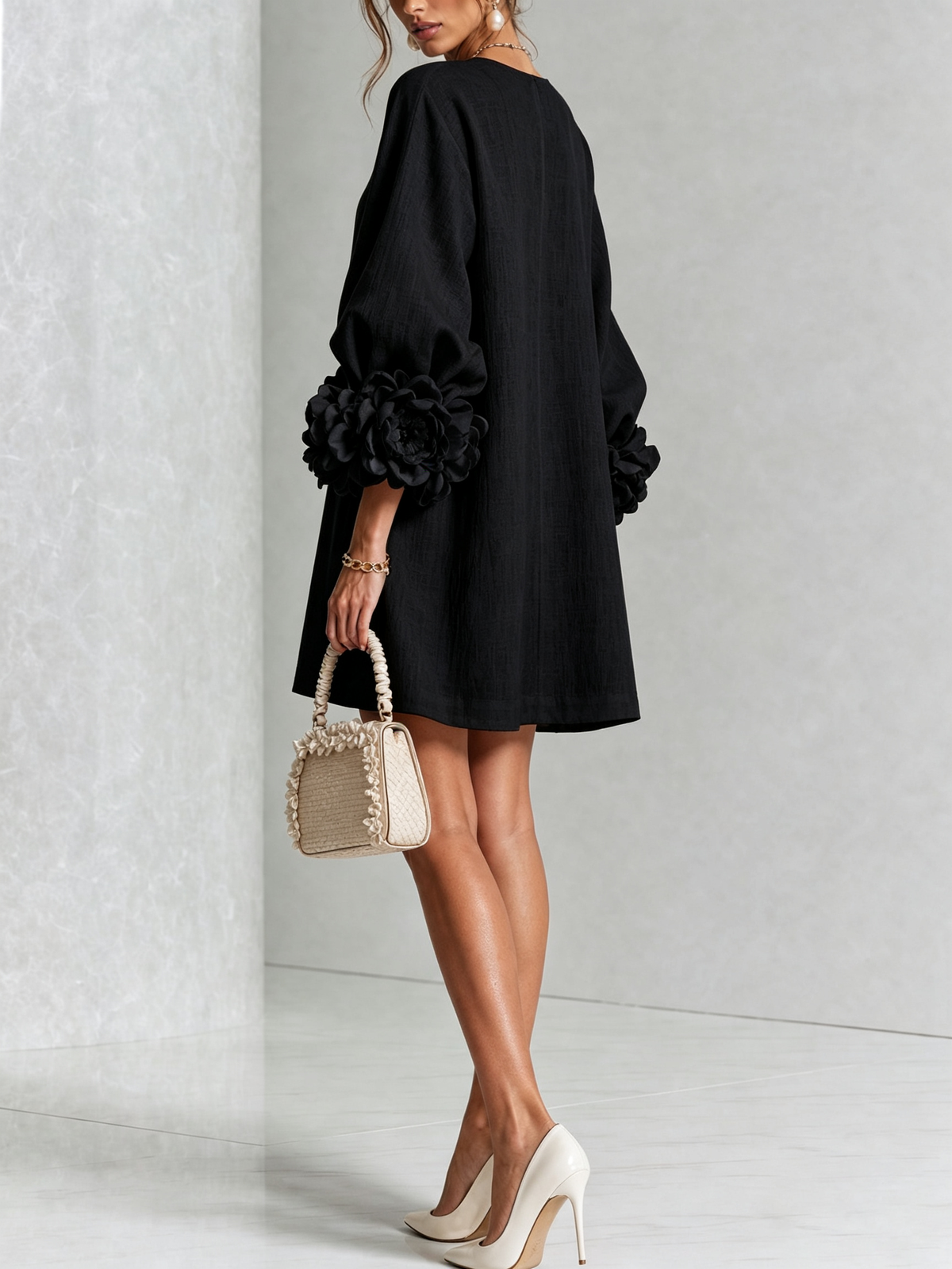 Black button-down mini dress with vertical button placket and rose-like cuff accents