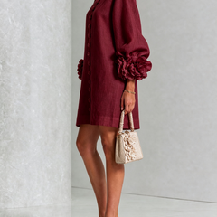 Burgundy button-down mini dress, side view, with vertical buttons and flowered puff sleeves