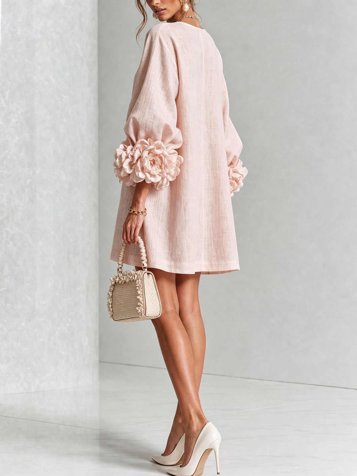 Blush button-down mini dress with long sleeves and rosette-style cuff details