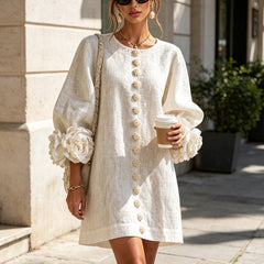 White button-down mini dress with puff sleeves, rosette cuffs, and vertical gold buttons