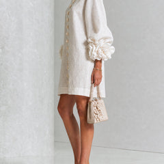 White mini dress with gathered puff sleeves and vertical gold button placket