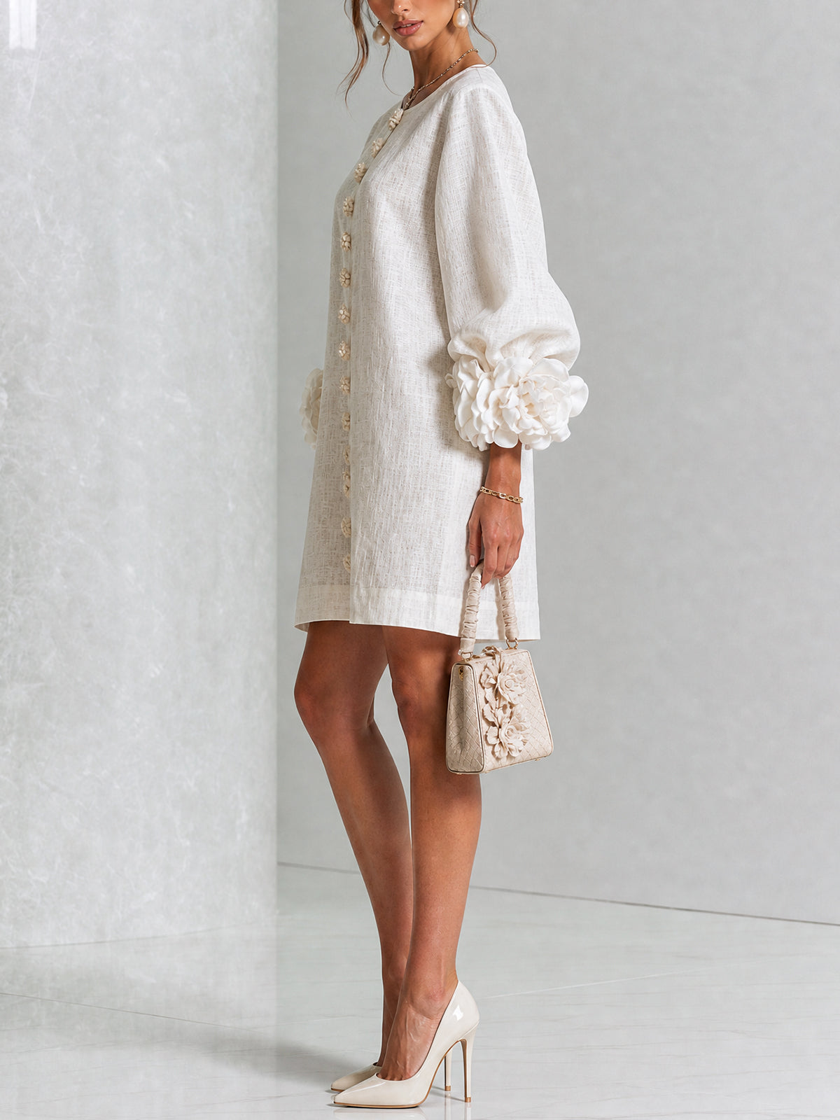 White mini dress with gathered puff sleeves and vertical gold button placket