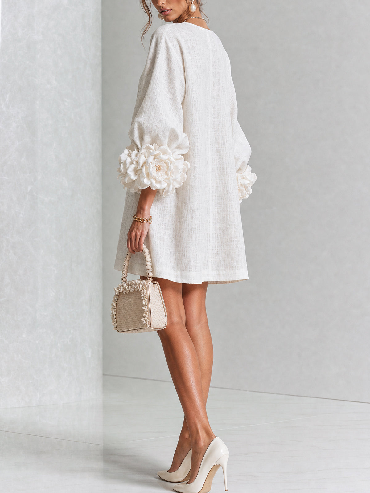 White button-down mini dress with large rosette cuff sleeves and gold buttons