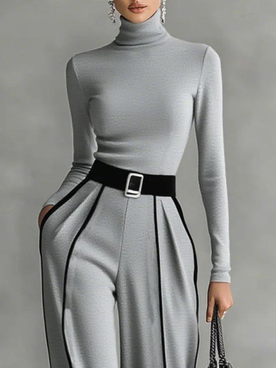 Grey high-neck long-sleeve top with waist belt buckle and pleated wide-leg pants with white trim.