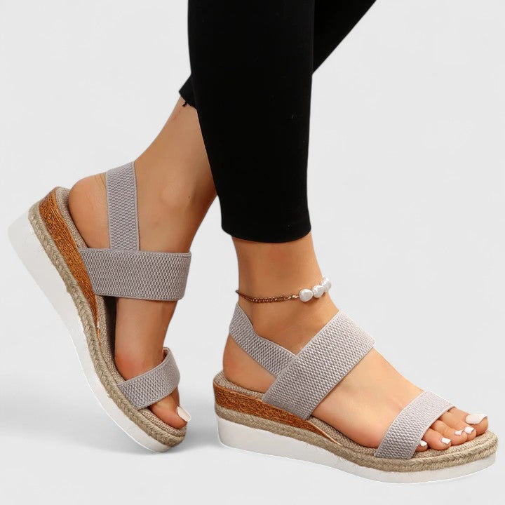 Orthopedic sandals in light gray with wide straps and delicate chain ankle bracelet