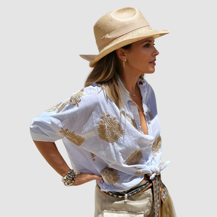 White breathable blouse with gold embroidered motif, V-neck and puff sleeves