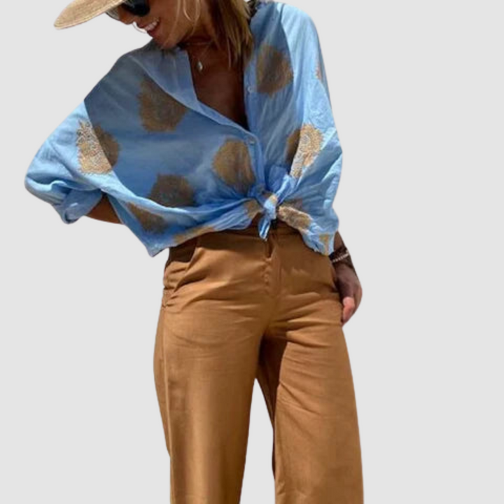 Blue breathable blouse with gold motif print, V-neck button front and long puff sleeves