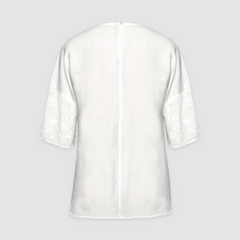 White back of loose-fit tunic shirt with floral sleeve detailing and center seam