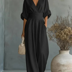 Black V-neck wide-leg jumpsuit with gathered waist and flowing full-length legs