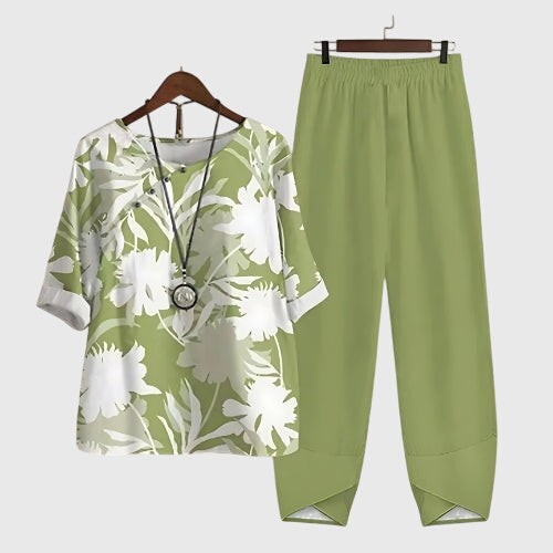 Two-piece set: green short-sleeve top and matching pants, white botanical leaf print