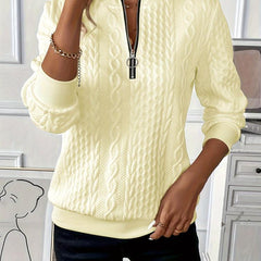 Light yellow zip-up cable knit sweater with long sleeves and metal zipper pull at center front