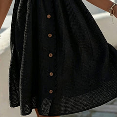 Black midi dress close-up: textured fabric and vertical button placket