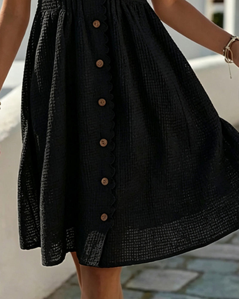 Black midi dress close-up: textured fabric and vertical button placket