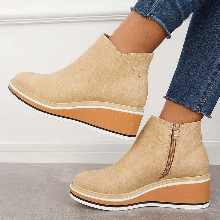 Beige ankle boots with side zipper and tan platform wedge sole with white edge