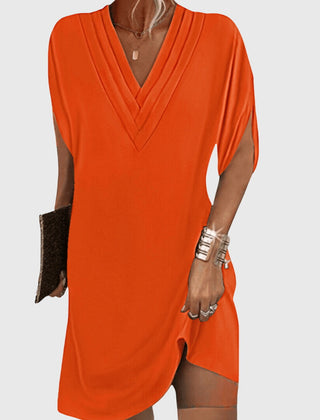 Orange draped V-neck dress with short sleeves and wrap-like crossover front