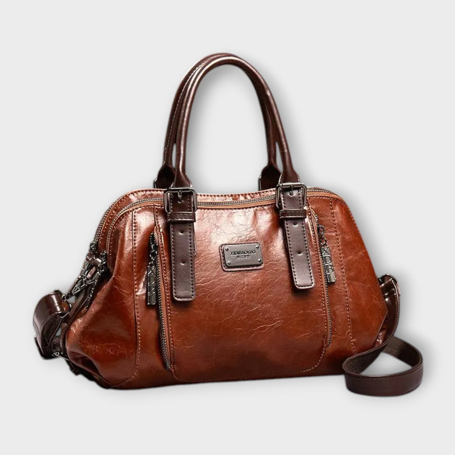 Brown leather-look shoulder bag with top handles, front logo plaque, zip top, crossbody strap.