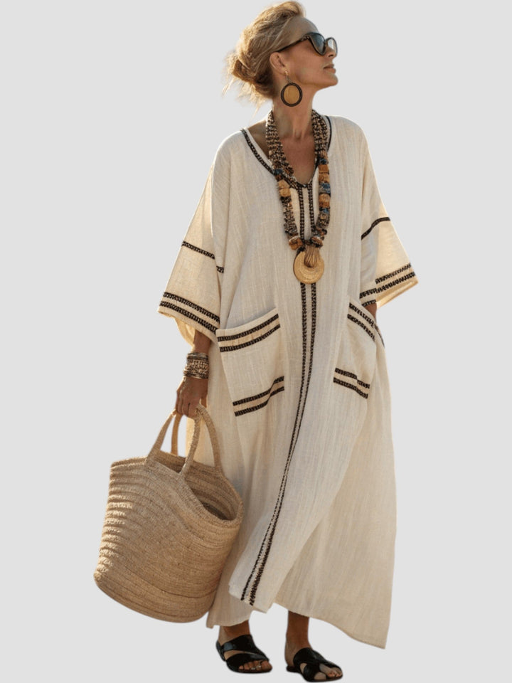 Light beige V-neck midi dress with black striped trim and loose swing hem