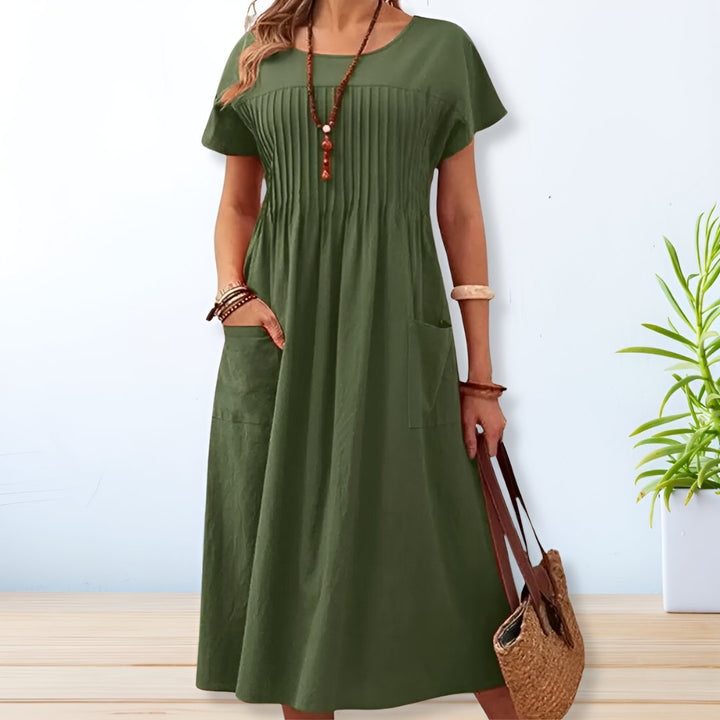 Green midi day dress, round neck, short sleeves, gathered front, patch pockets.