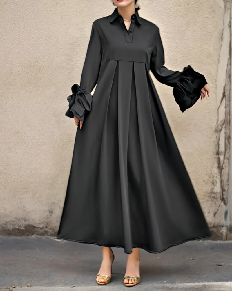 Black flared maxi shirt dress with collar, long sleeves, pleated skirt and ruffled cuffs