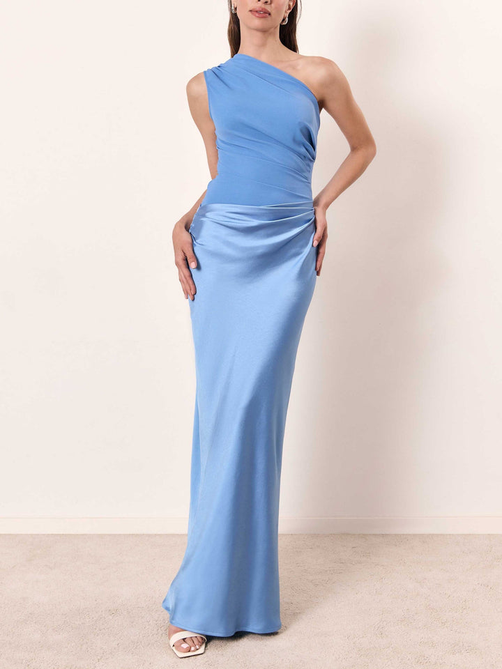 One-shoulder pleated satin maxi dress in light blue with draped waist and floor-length skirt.