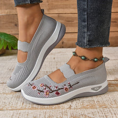 Gray knit slip-on orthopedic comfort shoes with floral stitching and wedge-style sole