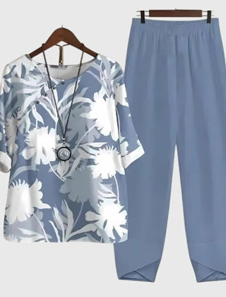 Two-piece set: light blue short-sleeve top and matching pants, white floral foliage print