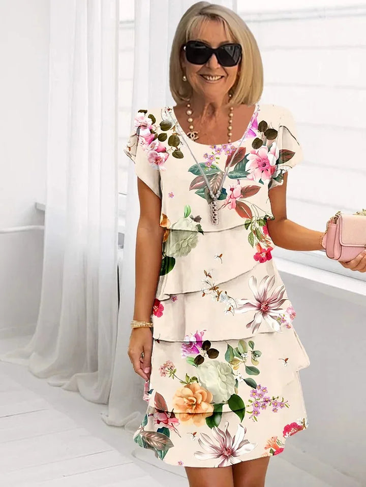 Tiered ruffled floral dress with short sleeves, white base with colorful botanical blooms