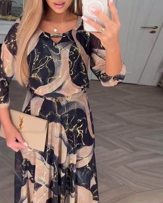 Chiffon maxi dress with abstract gold-on-dark pattern, ruffled neckline, fitted waist