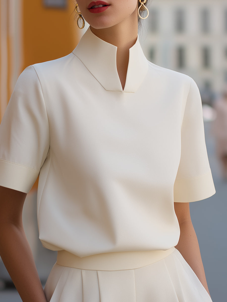White structured blouse with stand collar and short sleeves, fitted waistline silhouette