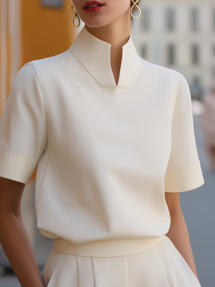 White structured blouse with stand collar and short sleeves, fitted waistline silhouette