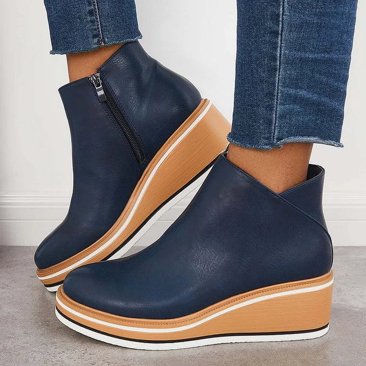 Blue ankle boots with side zipper and tan platform wedge with white sole trim