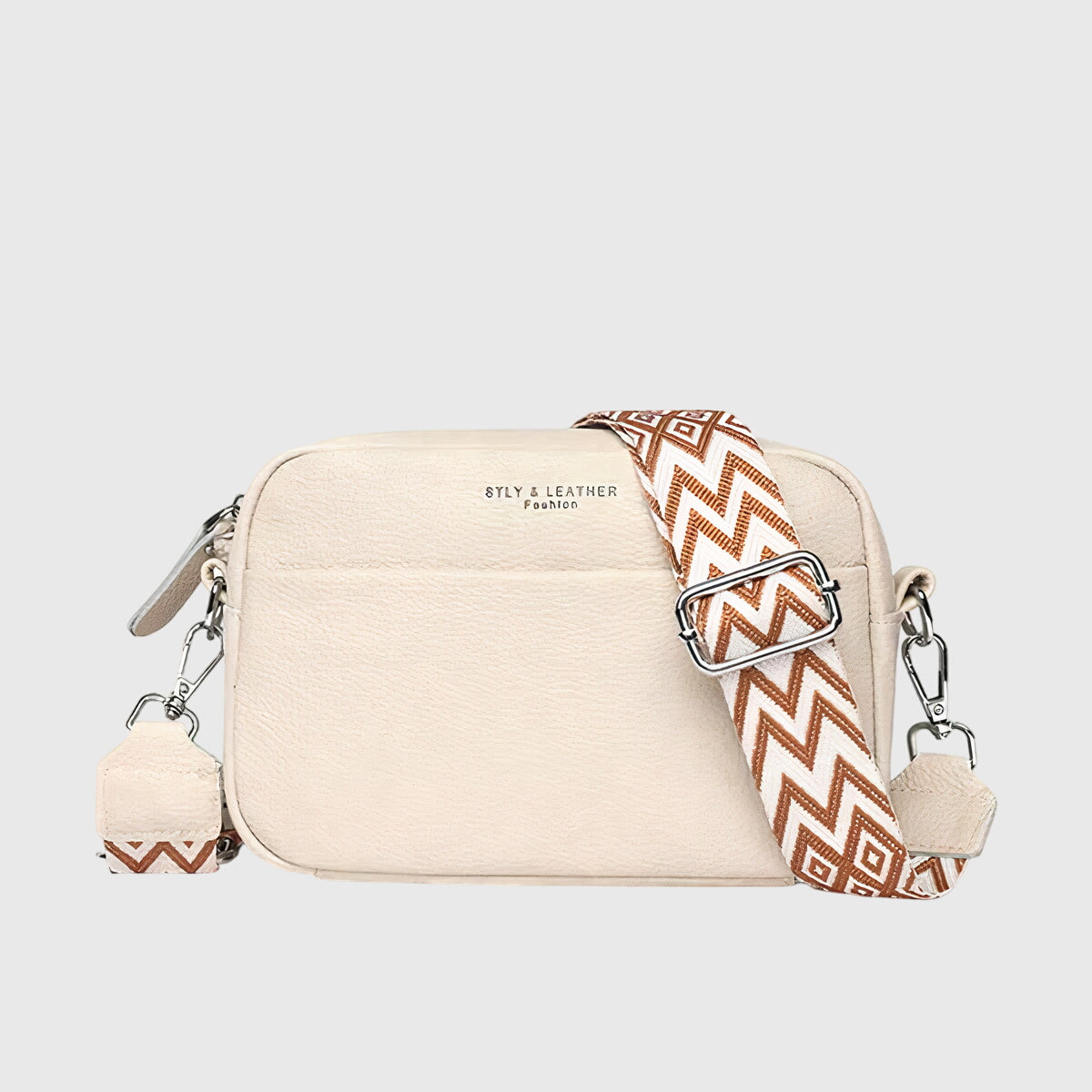 Beige leather shoulder bag with patterned chevron strap and side zipper pulls