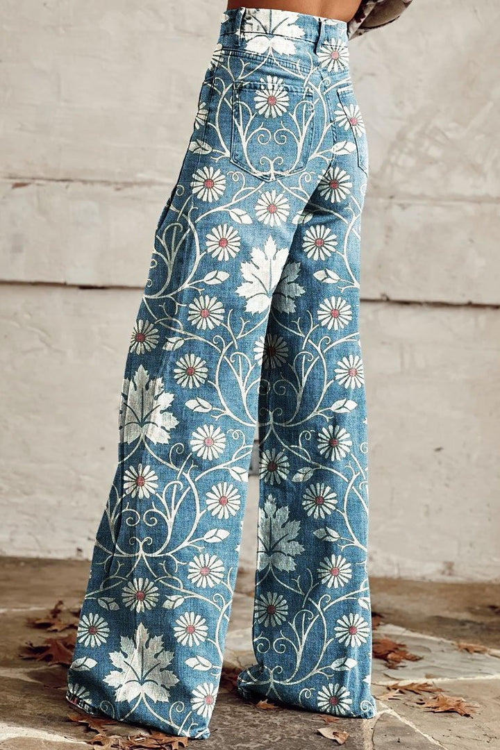 High-waist wide-leg jeans in blue with white daisy and swirl pattern, flared hem.