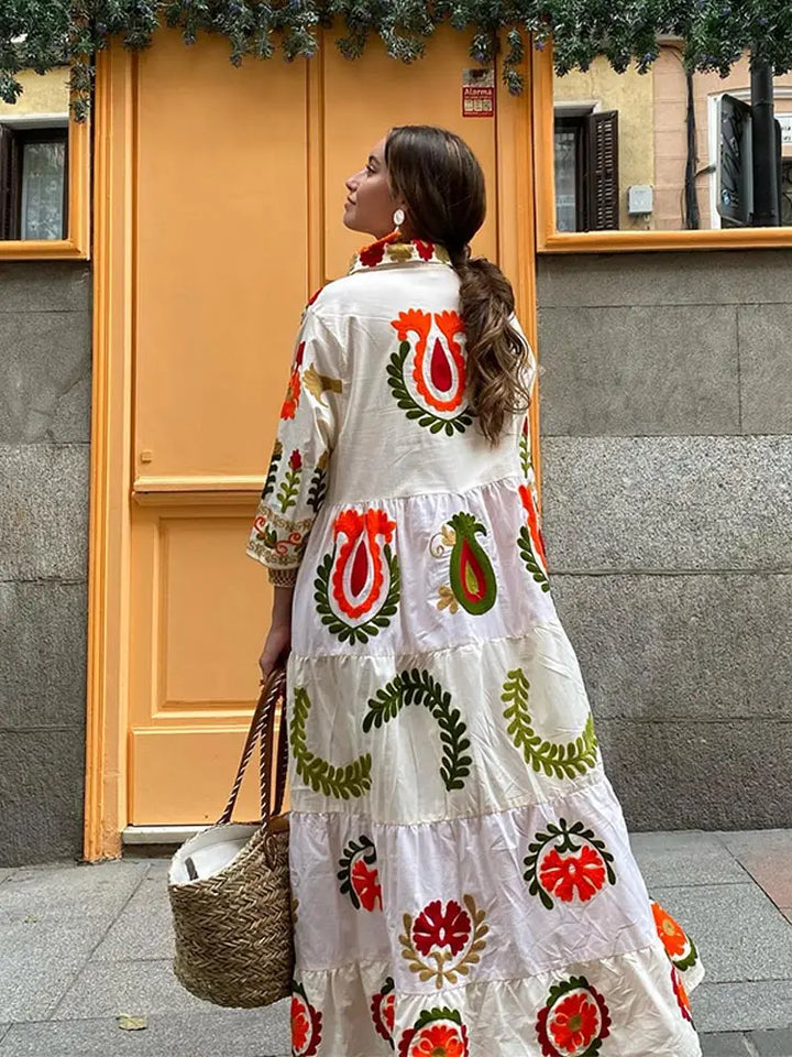 Back view of white boho dress with long sleeves and colorful folk floral pattern
