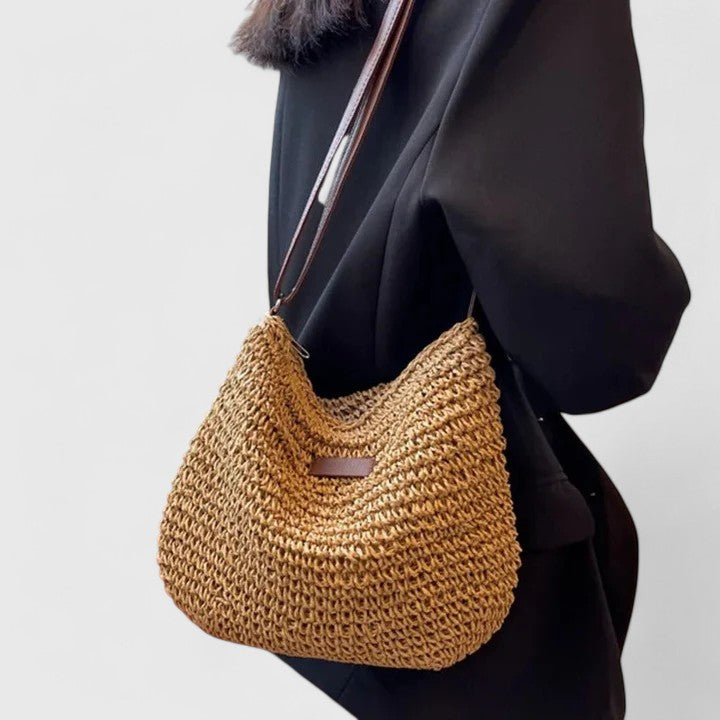 Khaki woven half-moon bag with brown leather strap and front logo patch
